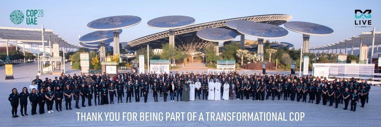 The COP28 UAE delivery team assembled at Expo City Dubai beneath the solar trees